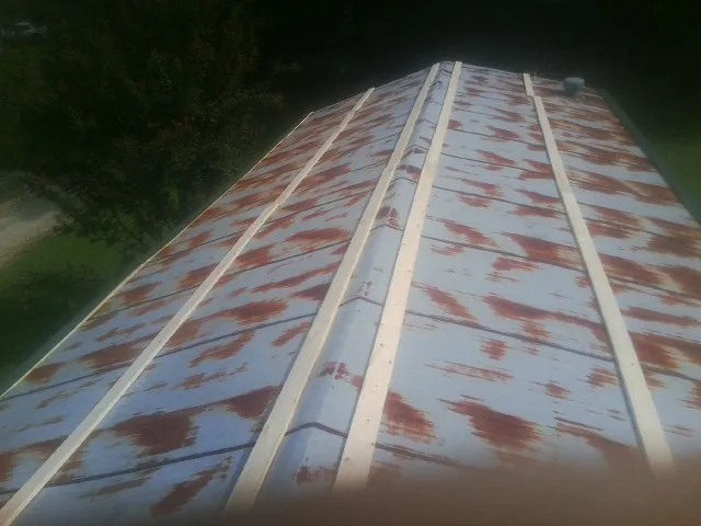 Rusted metal roof panels with new wood purlins before replacement — Storm Damage Roof Repair in Cornelia by Roofing Brothers