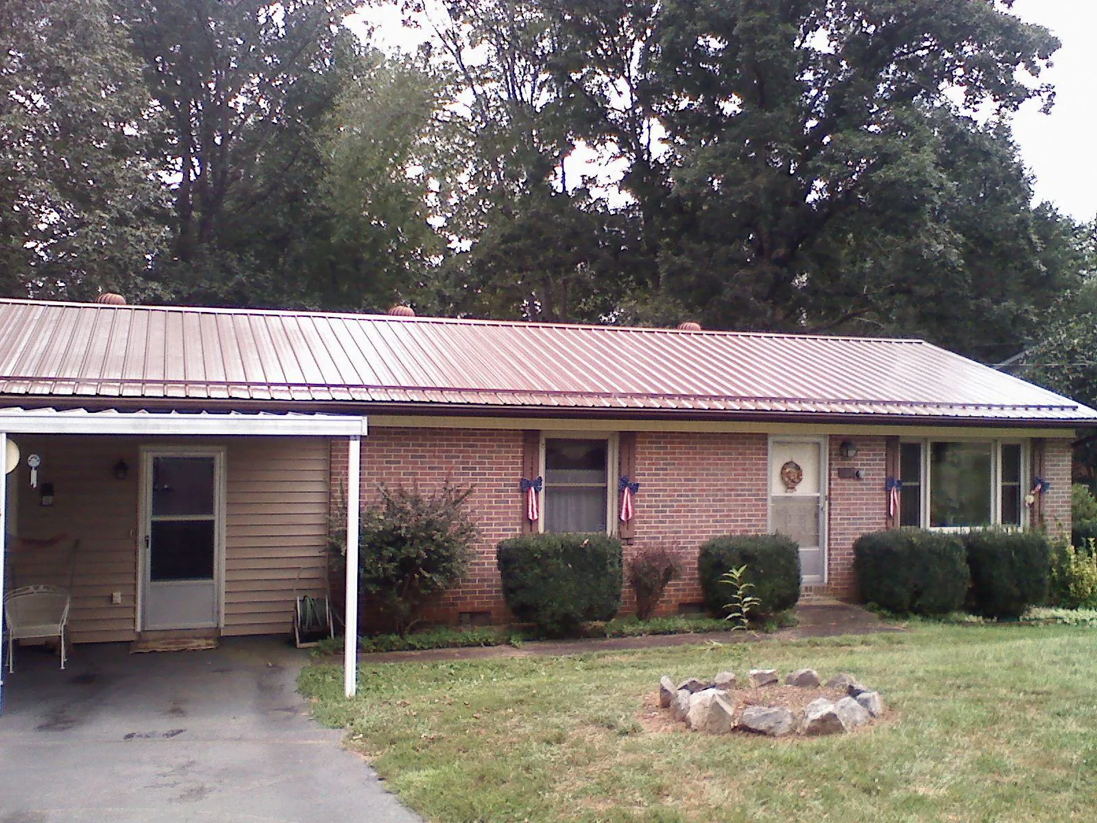 Bronze metal roof and carport on a brick ranch home — Roof Repair work by our crew in Cornelia